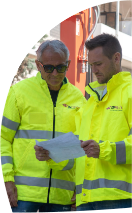 due operai vicino a un mezzo di lavoro sul cantiere