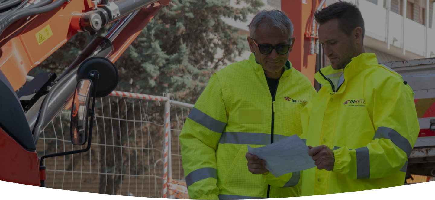 due operai vicino a un mezzo di lavoro sul cantiere
